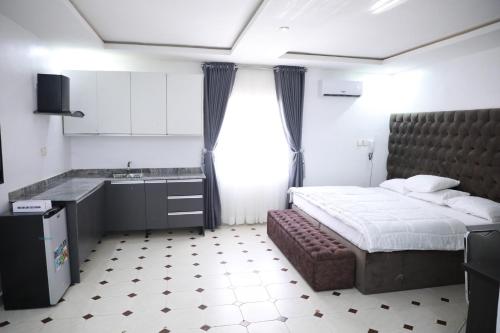 a bedroom with a bed and a sink and a kitchen at D & D Apartments in Abuja