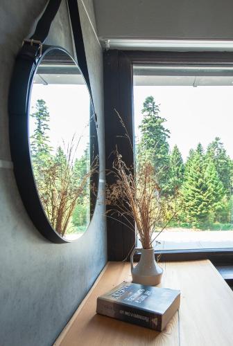 a mirror and a book and a vase on a table at "Park Hotel Ela" in Borovets