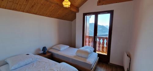 a room with two twin beds and a window at Le Panoramic 1300 in Notre-Dame-du-Pré