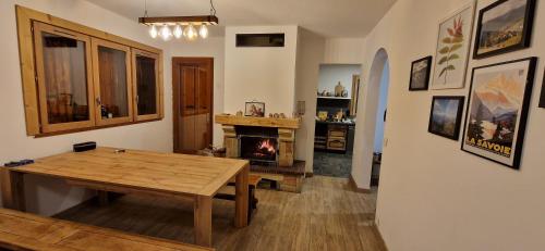 ein Wohnzimmer mit einem Holztisch und einem Kamin in der Unterkunft Le Panoramic 1300 in Notre-Dame-du-Pré