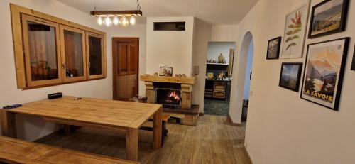 sala de estar con mesa de madera y chimenea en Le Panoramic 1300 en Notre-Dame-du-Pré