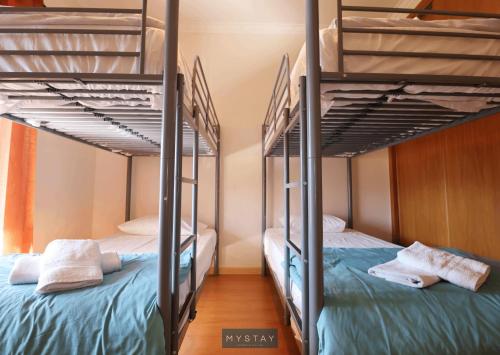 two bunk beds in a dorm room with blue beds at MyStay - Casa do Carmo in Alvite