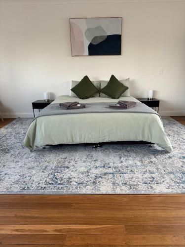 a bedroom with a large bed with a blue rug at Away on Blende Studio Loft in Broken Hill