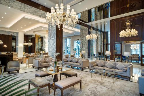 a lobby with couches and tables and chandeliers at Kaya Palazzo Resort & Casino in Kérynia