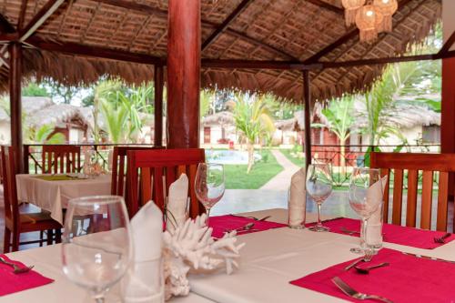 a table with wine glasses and napkins on top of it at Blue Sky Resort in Nosy Be