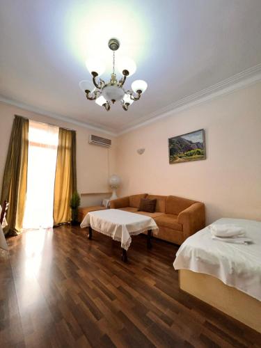 a room with two beds and a couch and a chandelier at Apartment on SARYAN street 2/12 in Yerevan
