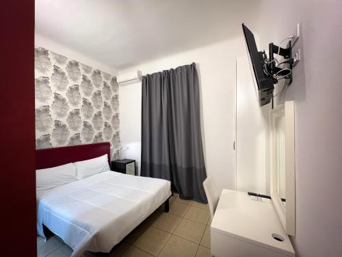 een slaapkamer met een bed en een tv. bij Hotel RossoVino Milano in Milaan