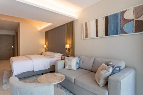 a hotel room with a couch and a bed at Hyatt Regency Kotor Bay Resort in Kotor