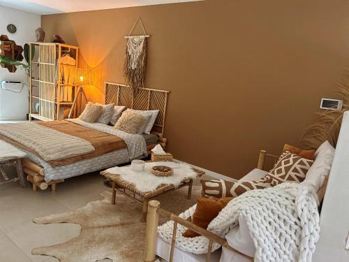 um quarto com uma cama, um sofá e uma mesa em Coco Suite em Amay