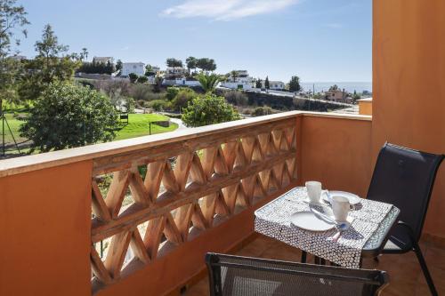 a balcony with a table and chairs with a view at Apartamento Baviera Golf 002 in Vélez-Málaga