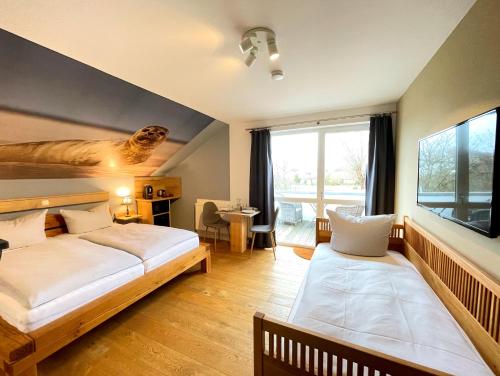 a bedroom with two beds and a large window at Haus zwischen den Wehlen bei Büsum, 16 Personen in Westerdeichstrich