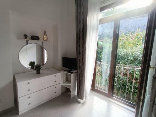 - une chambre avec un miroir, une commode et une fenêtre dans l'établissement La casa nel borgo, à Forlì del Sannio