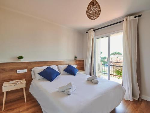 a bedroom with a large white bed with blue pillows at 0326 Apartment in Calella de Palafrugell in Calella de Palafrugell