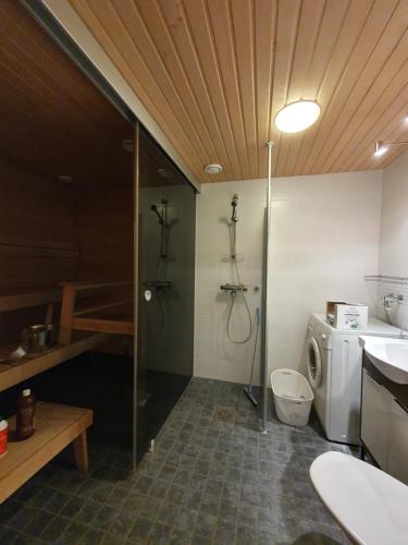 a bathroom with a shower and a washing machine at Ruka Park Base Camp in Ruka