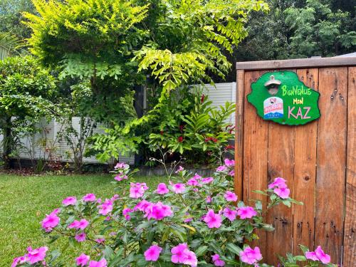 a garden with pink flowers and a sign on a fence at Villa Galabé et Tafia in Sainte-Marie
