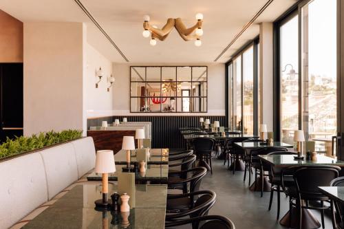 a restaurant with tables and chairs and large windows at The Rebello Hotel & Spa - Small Luxury Hotels Of The World in Vila Nova de Gaia