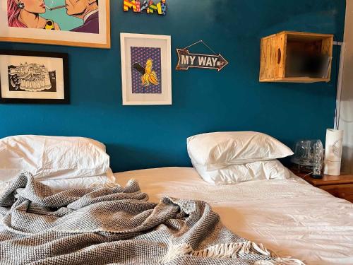 a bed in a room with a blue wall at Starry Starry Night - Route 62 in Montagu