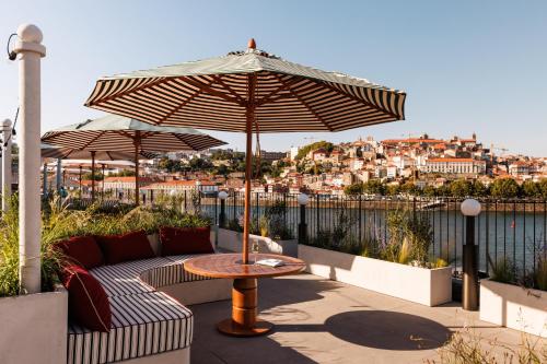 eine Terrasse mit einem Tisch und einem Sonnenschirm in der Unterkunft The Rebello Hotel & Spa - Small Luxury Hotels Of The World in Vila Nova de Gaia