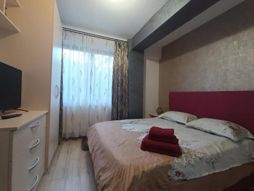 a bedroom with a bed with a red towel on it at Daylight Apartments Sibiu in Sibiu