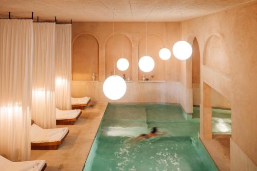 a person swimming in a indoor swimming pool at The Rebello Hotel & Spa - Small Luxury Hotels Of The World in Vila Nova de Gaia