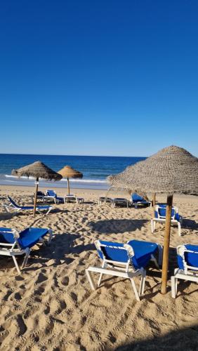 een groep stoelen en parasols op een strand bij Domek v srdci Fara in Faro