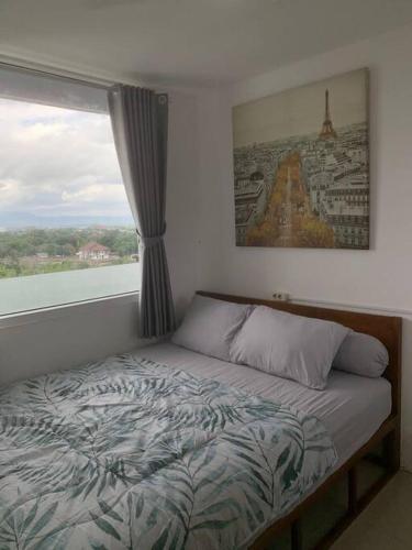 1 cama en un dormitorio con ventana en 2BR VIVO Apartement by MJP en Yogyakarta