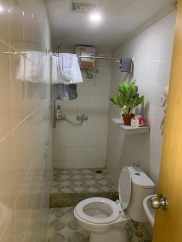 a bathroom with a toilet and a shower with towels at 2BR VIVO Apartement by MJP in Yogyakarta