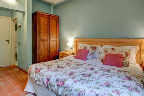 a bedroom with a large bed with pink pillows at Albergo Villa San Michele in Greve in Chianti