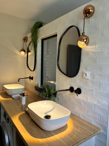 a bathroom with two white sinks and a mirror at Villa Galabé et Tafia in Sainte-Marie