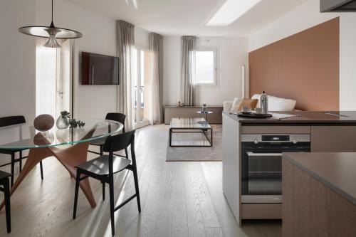 a kitchen and living room with a table and a dining room at Portopiccolo Apartments - Perla nel borgo in Sistiana
