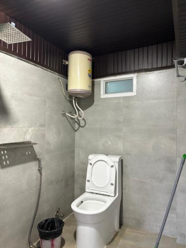 a bathroom with a toilet with a water tank at Hideout Backpackers Hostel in Darjeeling