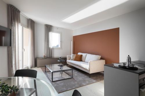 a living room with a couch and a table at Portopiccolo Apartments - Perla nel borgo in Sistiana