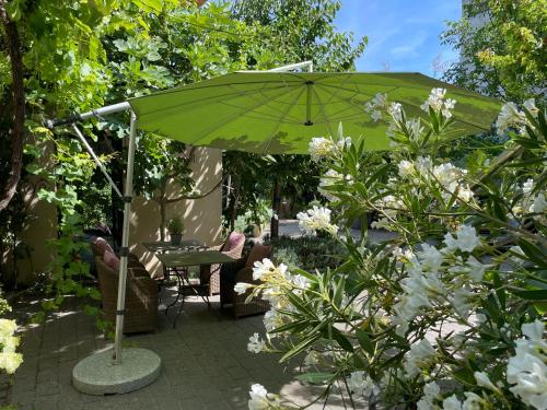 a green umbrella in a garden with flowers at Jugendstil-Hof in Langenlonsheim