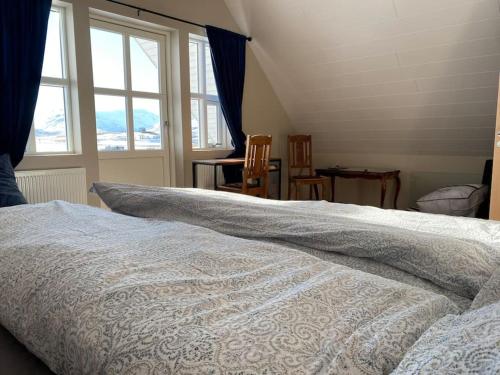 Schlafzimmer mit einem weißen Bett und einem Fenster in der Unterkunft Efri-Rauðilækur in Hörgársveit in Akureyri