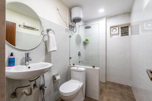 un bagno con un water, un lavandino e uno specchio di Eminent Suites and Apartments a Hyderabad