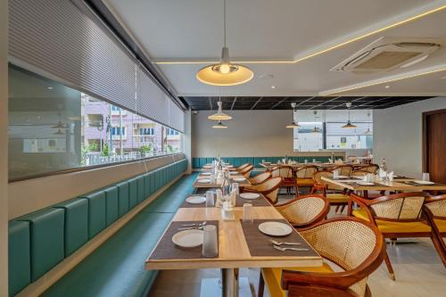una sala da pranzo con tavoli e sedie in legno di Eminent Suites and Apartments a Hyderabad