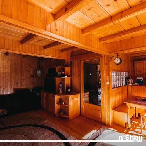 a wooden room with a table and a clock on the ceiling at N'SHPII VILLA in Peje