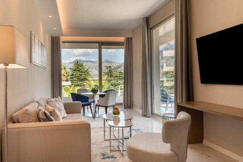 a living room with a couch and a table with chairs at Hyatt Regency Kotor Bay Resort in Kotor
