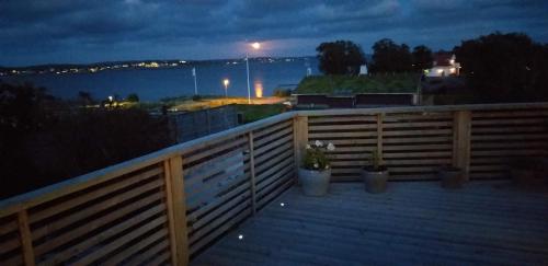 a deck with potted plants on a fence at night at Studio Snäckeberg in Åsa
