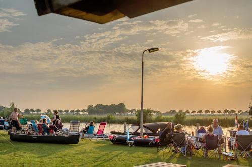 a group of people sitting in chairs on the beach at Camping Tussen de Diepen in Blokzijl