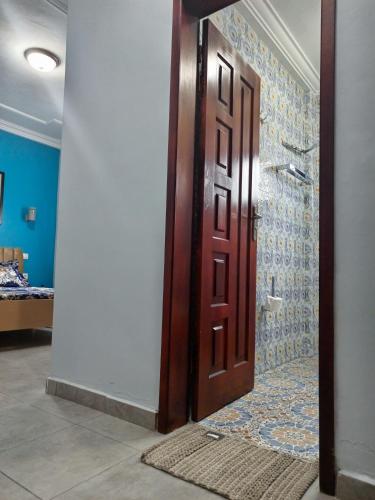 a wooden door in a room with a bathroom at Matera YameHome in Yaoundé