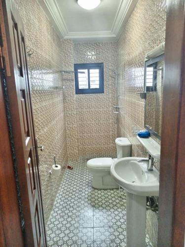 a bathroom with a toilet and a sink at Matera YameHome in Yaoundé