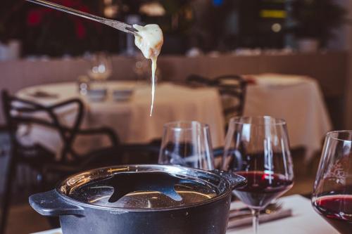 a pot of wine sitting on a table with wine glasses at Hotel Morgana in Mendrisio