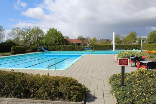 a swimming pool in a yard with a sign next to it at Camping Tussen de Diepen in Blokzijl