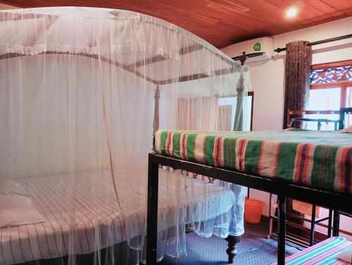 a bedroom with a bed with a canopy at Green Herbal Ayurvedic Eco-Lodge in Galle