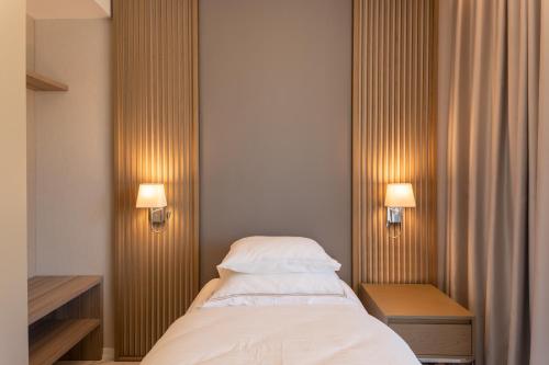 a bedroom with a bed and two lights on the wall at Hyatt Regency Kotor Bay Resort in Kotor