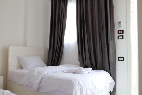 1 dormitorio con 1 cama con sábanas blancas y ventana en Diamond Guest House, en Luxor
