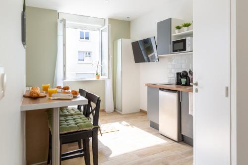 une cuisine avec une table et des chaises et une cuisine avec un évier dans l'établissement STUDIOS proximité Facs, Clinique Pasteur, Centre, à Brest