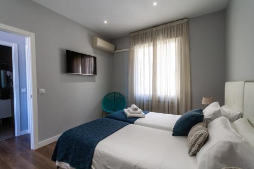 Un dormitorio con una gran cama blanca y una ventana en Noa Apartment, en Madrid