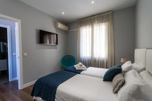 a bedroom with a large white bed and a window at Noa Apartment in Madrid